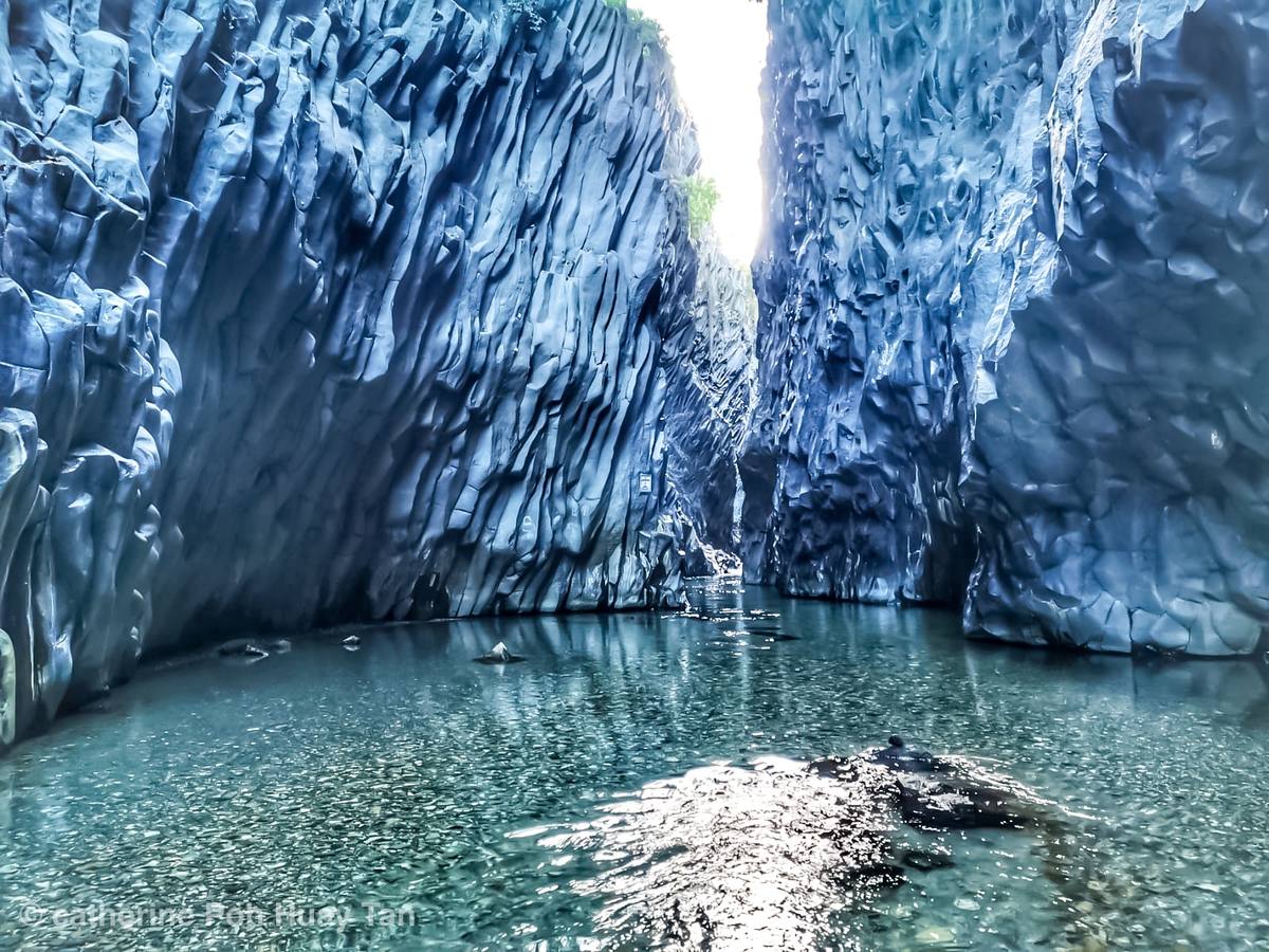 Canyon con pareti di roccia scura e fiume che scorre in basso
